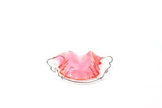 Red retainer upper teeth to maintain the teeth after removing the braces isolated on white background.