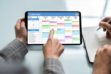 Fototapeta na wymiar Businessperson Looking At Calendar On Digital Tablet