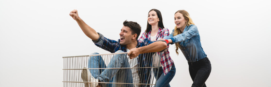 The three people fun with a shopping cart on a white wall background