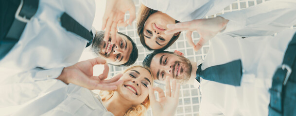 The four happy people gesture to the camera