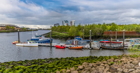 Fototapeta premium A view of boats moored on the River Kelvin where it joins the River Clyde in Glasgow on a summers day