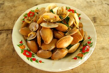 Spicy Thai food stir fried clams with basil leaves on the plate stock photo
