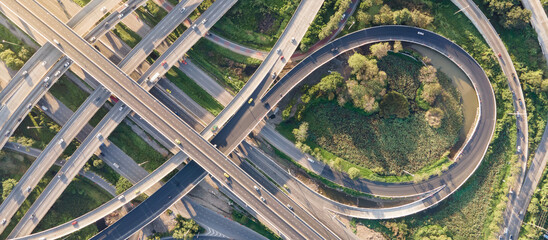 Aerial view of road interchange or highway intersection with busy urban traffic speeding on the...