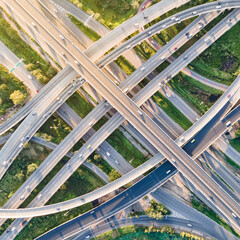 Aerial view of road interchange or highway intersection with busy urban traffic speeding on the...