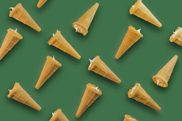 Waffle cones with white sweet filling on the background of the color of the crown of trees. Sweet waffle cones with filling. The image of a sweet treat.