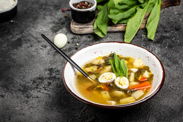 Delicious sorrel soup with eggs, potatoes, carrots, parsley. Food recipe background. Close up, top view