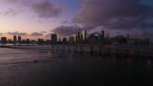Miami at Evening Twilight. City Downtown and Rickenbacker Causeway. Blue Hour. Urban Cityscape. Aerial View. Florida, USA. Drone Flies Forward and Upwards