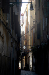 View of a Venice narrow street (In dialect "Calle"), in the early morning. Old but charming backstreet under a delicate sun beam.