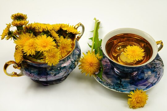 A Porcelain Blue Vase With A Bouquet Of Dandelions And A Blue Porcelain Cup With Dandelion Tea Are On A White Table