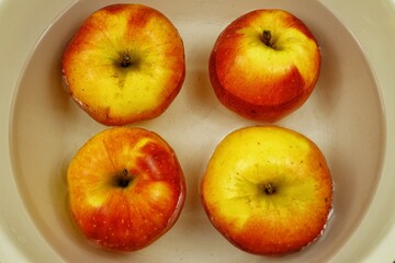 Red and yellow apples lie in the water 