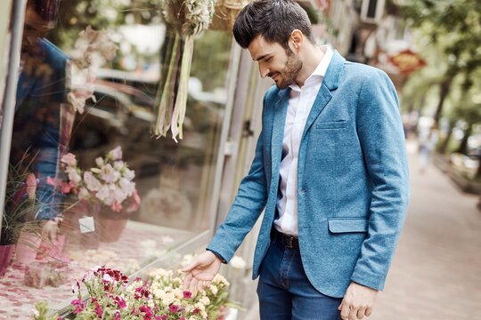 Young man buying flowers outdoors.