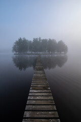 Naklejka na ściany i meble wooden bridge on island in fog