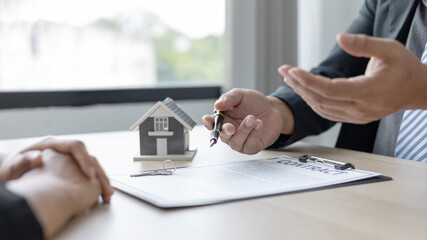 Real estate agent or sales manager talks to clients about the terms of buying a home and collateral...