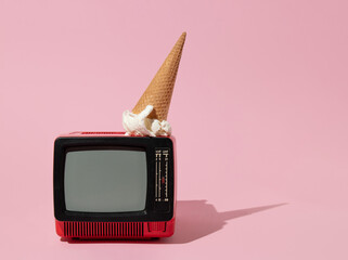 Creative layout with old tv and ice cream cone up side down on pastel pink background. Retro style...