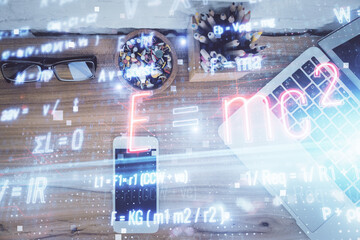 Double exposure of formula drawing over table with phone. Top view. Education concept.