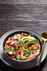Mexican chicken and tortilla soup on a black plate