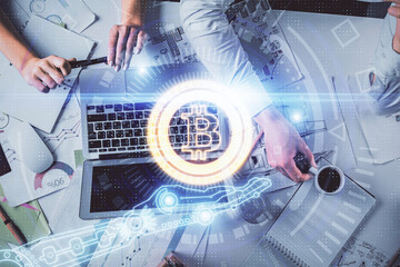 Double exposure of man and woman working together and crypto finance theme hologram. Blockchain business concept. Computer background.