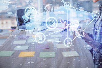 Double exposure of woman hands typing on computer and social network theme hologram drawing. People media concept.