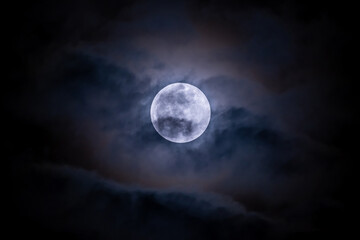 Fototapeta na wymiar Full moon shining on the sky in cloudy day.