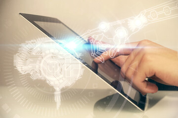 Double exposure of man's hand holding and using a digital device and brain hologram drawing. Data concept.