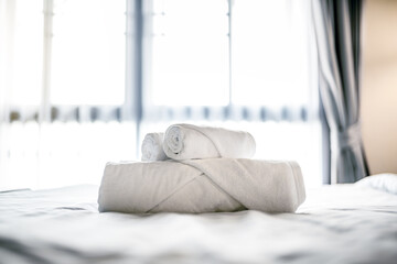 clean towel decoration on the bed in white bedroom at morning