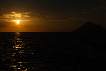 Fototapeta premium sunset in the middle of the sea and the mountain island