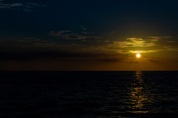 sunset in the middle of the sea with silhouette of the ocean