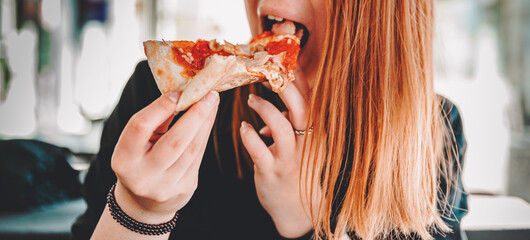 woman Hand takes a slice of meat Pizza. young woman eating pizza outdoor in street
