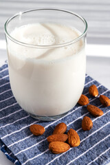 A glass of almond milk with almonds around