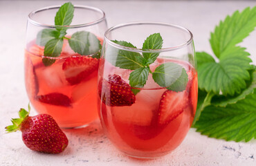 
Two glasses of refreshing strawberry drink on a white background.