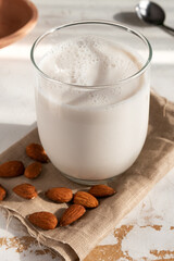 A glass of almond milk with almonds around