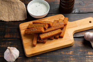 appetizing toasted toasts from rye bread on dark wooden background