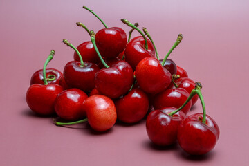 Pile of fresh cherries on pink background
