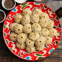 Stuffed dumplings, manti of dough and minced on wooden background