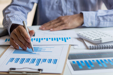 Financial Business man analyze the graph of the company's performance to create profits and growth, Market research reports and income statistics, Financial and Accounting concept.