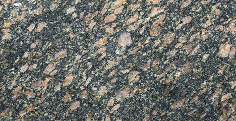 Surface of a granite stone. Pink and black texture of a polished natural crystalline rock