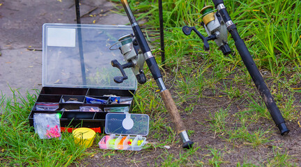 Fishing rod, spinning reel and a cup of hot coffee on the bank of the river pier. Out-of-town...