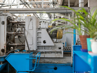 View of the shop for the production of machine parts with old equipment and pot plants. Production hall