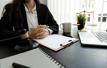 female lawyer working with contract papers and wooden gavel on table in courtroom. justice and law ,attorney, court judge, concept.