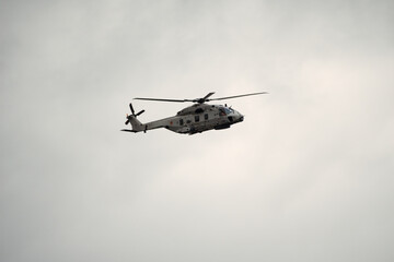 Fototapeta premium Sea military helicopter (airforce) in flight at Koksijde on a rainy and cloudy day ready for combat