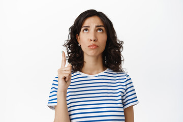 Sad disappointed girl, express regret, pointing up feel unfair, complaining on bad logo, standing...