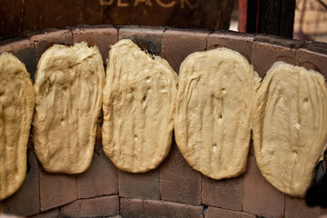 Women make bread by hand according to old recipes in an open oven. Handmade bread. Traditional...