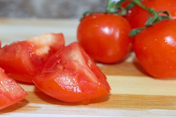 Tomato slices on wooden background, healthy vegetables.