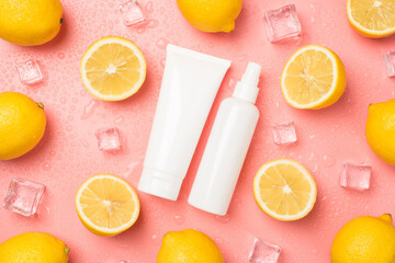 Top view photo of white cream tube and spray bottle without label in the middle ice cubes water drops halves and whole lemons on isolated pastel pink background with copyspace