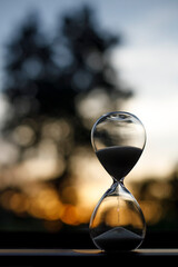 hourglass and the light of the setting sun,
silhouette, vertical image