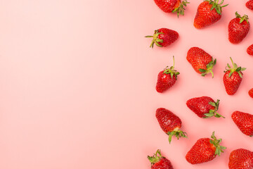 Top view photo of strawberries on the right on isolated pastel pink background with copyspace on the left