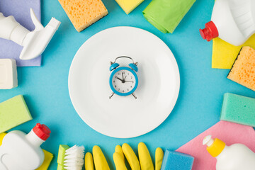 Overhead photo of colorful equipment for cleaning and plate with alarm clock in the middle isolated on the blue background