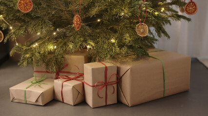 Naklejka na ściany i meble christmas gifts under spruce indoor with warm light
