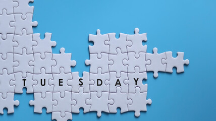 TUESDAY word written on white jigsaw puzzle