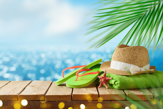 Tropical summer concept with beach accessories on wooden board over sea beach background. Holidays vacation concept